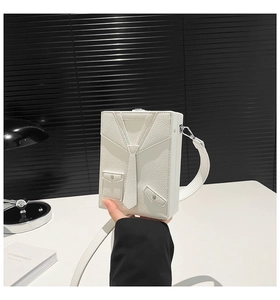Detailed close-up of a white box bag with creative suit design and leather texture