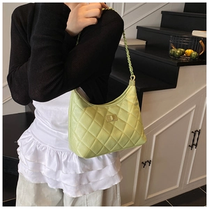 Detail view of light green quilted shoulder bag with metal turn-lock and chain strap
