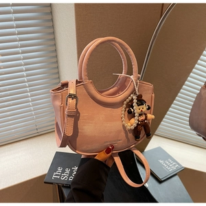 Pink semi-circular leather handbag detail with pearl chain and cute doll charm