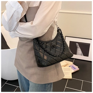 Detail shot of black quilted shoulder bag featuring retro chain and turn-lock closure