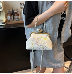 Detail of white embroidery evening bag with pearls and vintage floral patterns