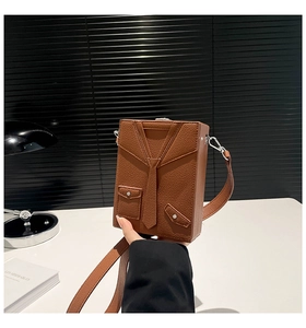 Detail of creative brown blazer-shaped crossbody bag with suit lapels and textured leather