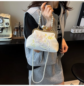 Detailed embroidery and large pearl clasp on elegant white floral evening clutch bag