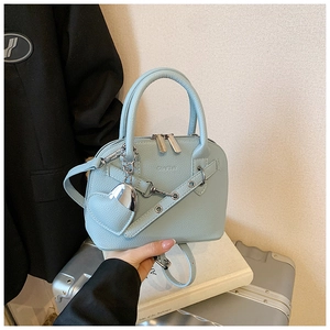 Close-up of sky blue shell bag with litchi texture leather and heart shaped charm