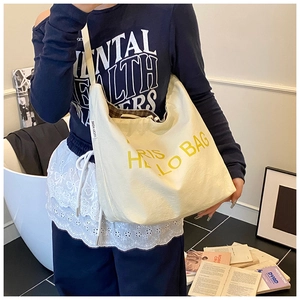 Nahaufnahme der cremefarbenen Canvas-Hobo-Tasche mit kariertem Futter und PARIS-Text