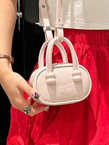 Chic light pink mini oval crossbody bag with top handles for women in a stylish design