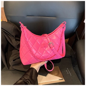 Close-up of quilted rose red chain bag with metal square buckle and woven strap details