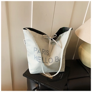 Detail der Canvas-Einkaufstasche mit PARIS-Druck und grünem Karofutter mit Schleife