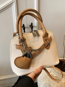Chic shell-shaped beige leather handbag with brown handles and a heart charm for women