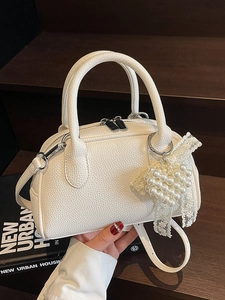 Borsa a mano bianca con trama litchi, pendente a cuore di perle e finiture in pizzo
