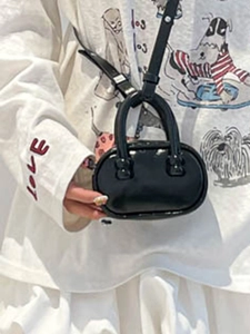 Minimalist black patent leather square handbag shown as a stylish crossbody shoulder bag