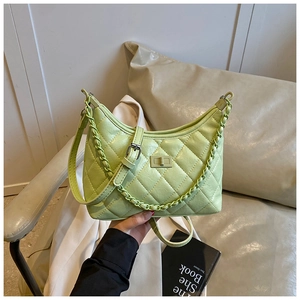 Close-up of light green quilted shoulder bag featuring metallic twist lock and chain strap