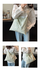 Detailed shot of floral tote bag featuring white lace trim and light blue flower pattern
