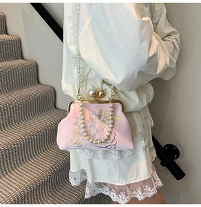 Detailed embroidery on pink satin evening bag with dual pearl straps and metal clasp