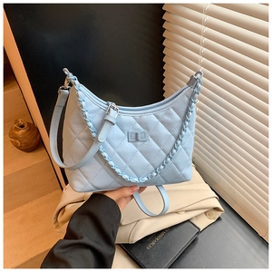 Detail of light blue quilted hobo bag with thick chain strap and adjustable leather strap