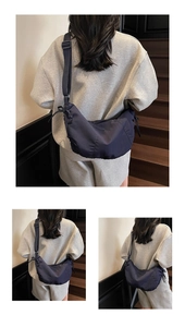 Detail showing durable navy nylon fabric and adjustable strap of this spacious crescent bag