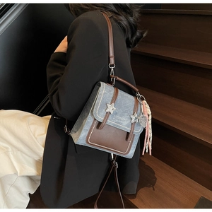 Detail view of the vintage blue and brown backpack with star studs on wooden stairs