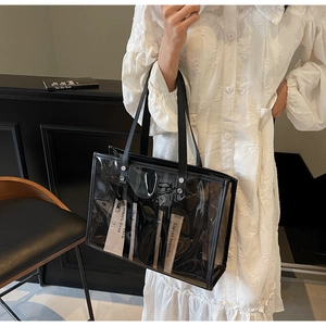 Detail of transparent PVC tote bag with black leather straps and silver metal rivets
