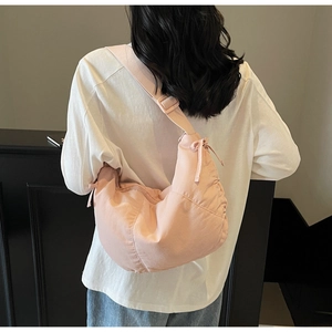 Detailed view of pink crescent tote with drawstring closure and adjustable wide strap