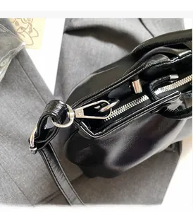 Close-up of premium black leather texture and polished silver hardware on women's handbag
