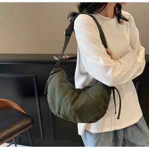 Detail of olive green crescent tote bag with side drawstrings and wide shoulder strap