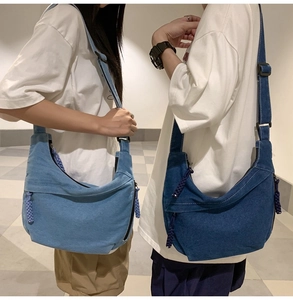 Détail de la bandoulière réglable et sacs hobo en denim aux finitions bleu clair et foncé