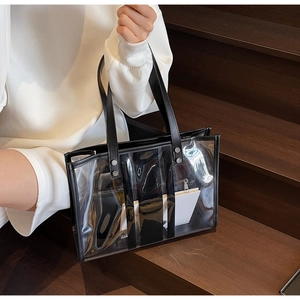Detail showing transparent PVC tote bag with black leather trim and inner pouch on stairs
