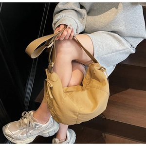 Detail of khaki crescent canvas tote with drawstring design and adjustable shoulder strap