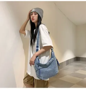 Détails d'un sac fourre-tout en denim bleu avec coutures blanches et cordon de fermeture éclair
