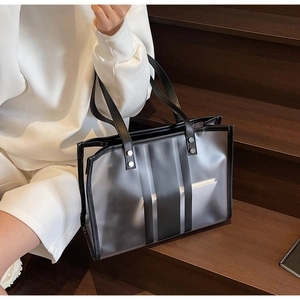 Detail of transparent black tote bag with vertical stripes on wooden stairs
