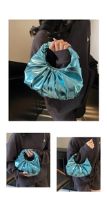 Detail view of metallic bright blue pleated handbag with a unique half-moon cloud shape
