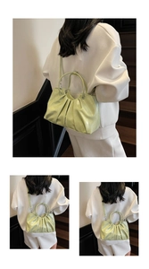 Close-up detail of light green pleated bucket bag showing soft leather texture and handle