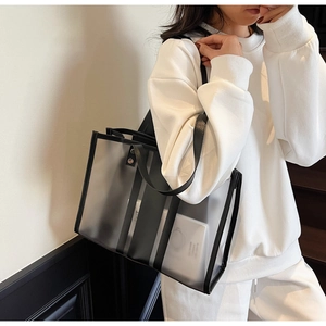 Detail of transparent PVC tote bag with black trim and inner white pouch for women