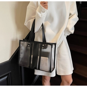 Detail of transparent PVC tote bag with black leather trim and vertical stripes