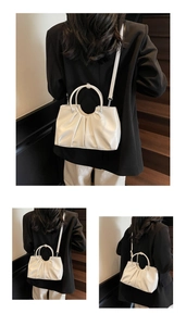 Detail shot of the off-white pleated bucket bag with round handles and adjustable strap
