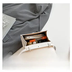 Vue intérieure d'un petit sac bandoulière blanc montrant le rangement du mobile