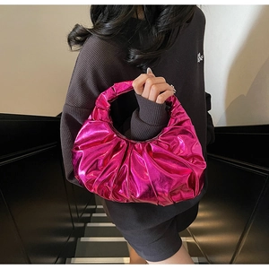 Detail shot of bright pink metallic pleated handbag with a modern half-moon shape