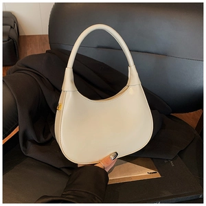 Detailed macro view of cream-colored leather hobo bag with gold hardware and side zipper