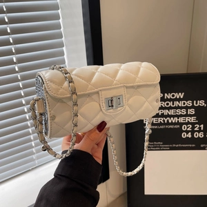 Détail du sac cylindre blanc matelassé avec fermoir rotatif et bandoulière chaîne