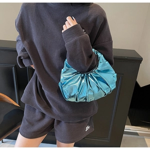 Detailed view of shiny metallic blue pleated hobo bag with unique wrinkled texture