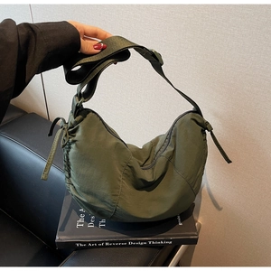 Detail view of army green nylon hobo bag with drawstring side and wide shoulder strap