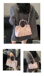 Detail of light pink pleated handbag with adjustable shoulder strap and smooth PU leather