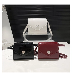 Trois sacs bandoulière en cuir verni blanc, noir et bordeaux avec boucles argentées