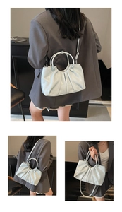Detail of light blue pleated oil-wax leather handbag with circular metal ring handle