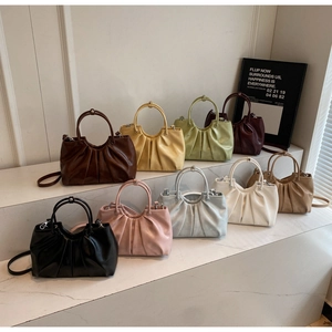 Detailed collection of ruched cloud handbags in various colors on marble display