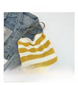 Detail view of yellow and white striped knit tote with adjustable leather strap