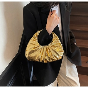 Detail of a metallic gold pleated handbag featuring a vintage cloud-style fashion design