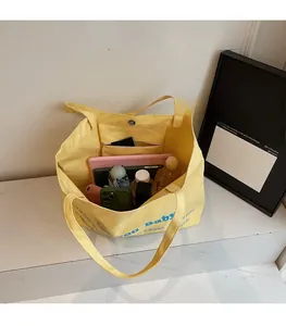Detailed interior view of a spacious yellow canvas tote bag showing large storage capacity