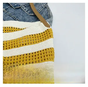 Close-up of yellow and white striped knitted tote bag with hollow mesh and brown leather strap