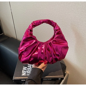 Close-up of metallic magenta pleated handbag with unique ruffled handle design